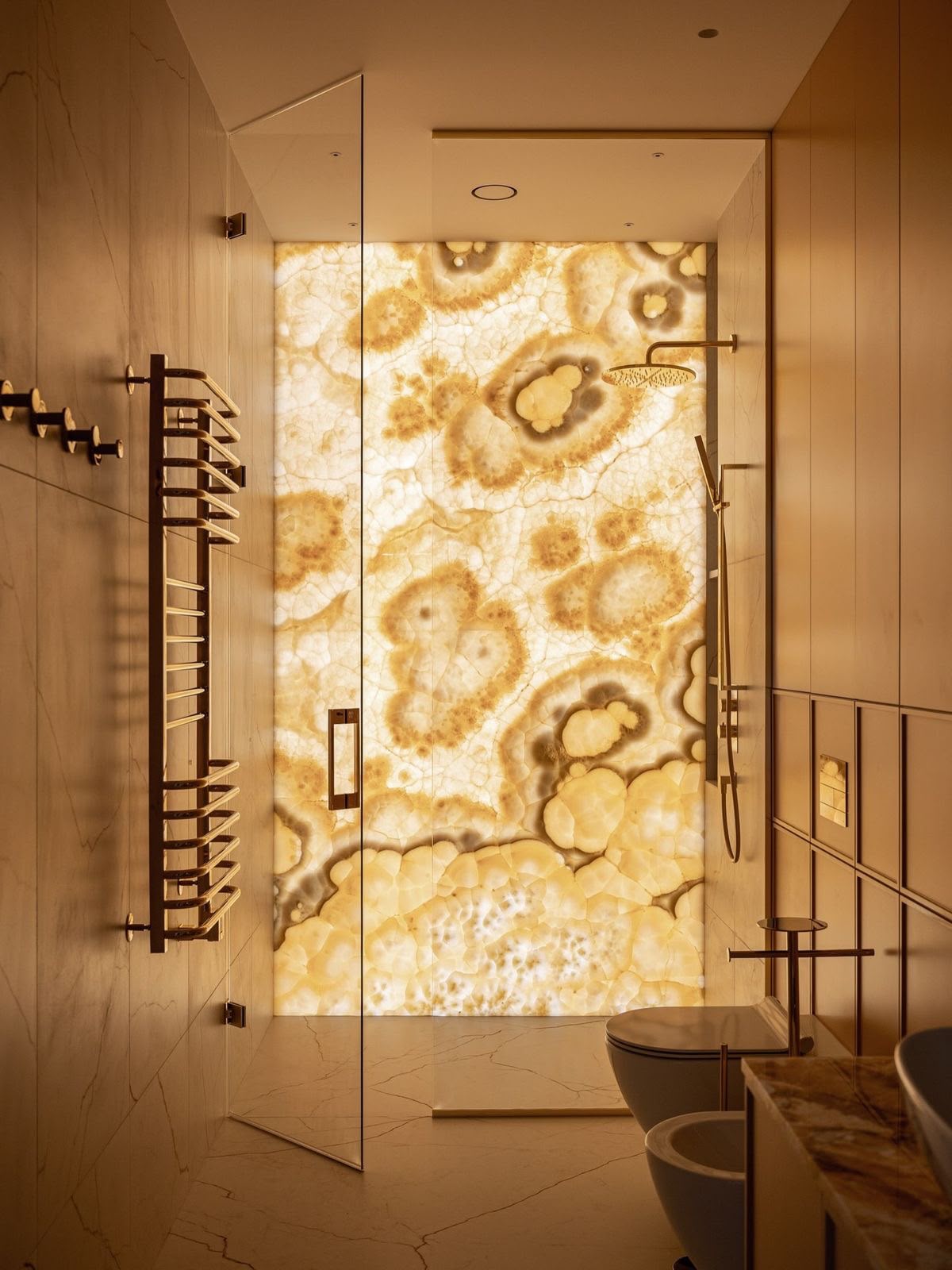 Luxusbad mit Waschtisch aus dunklem Marmor und goldener Mosaikwand