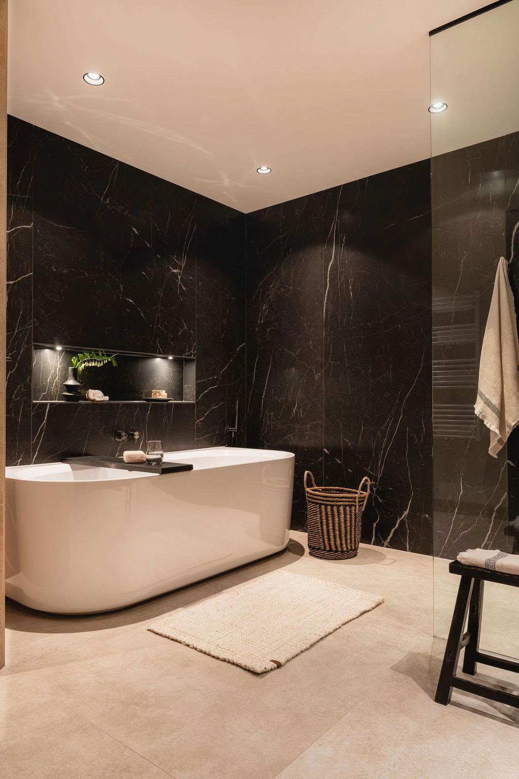 Freistehende Wanne vor schwarzer Marmorwand